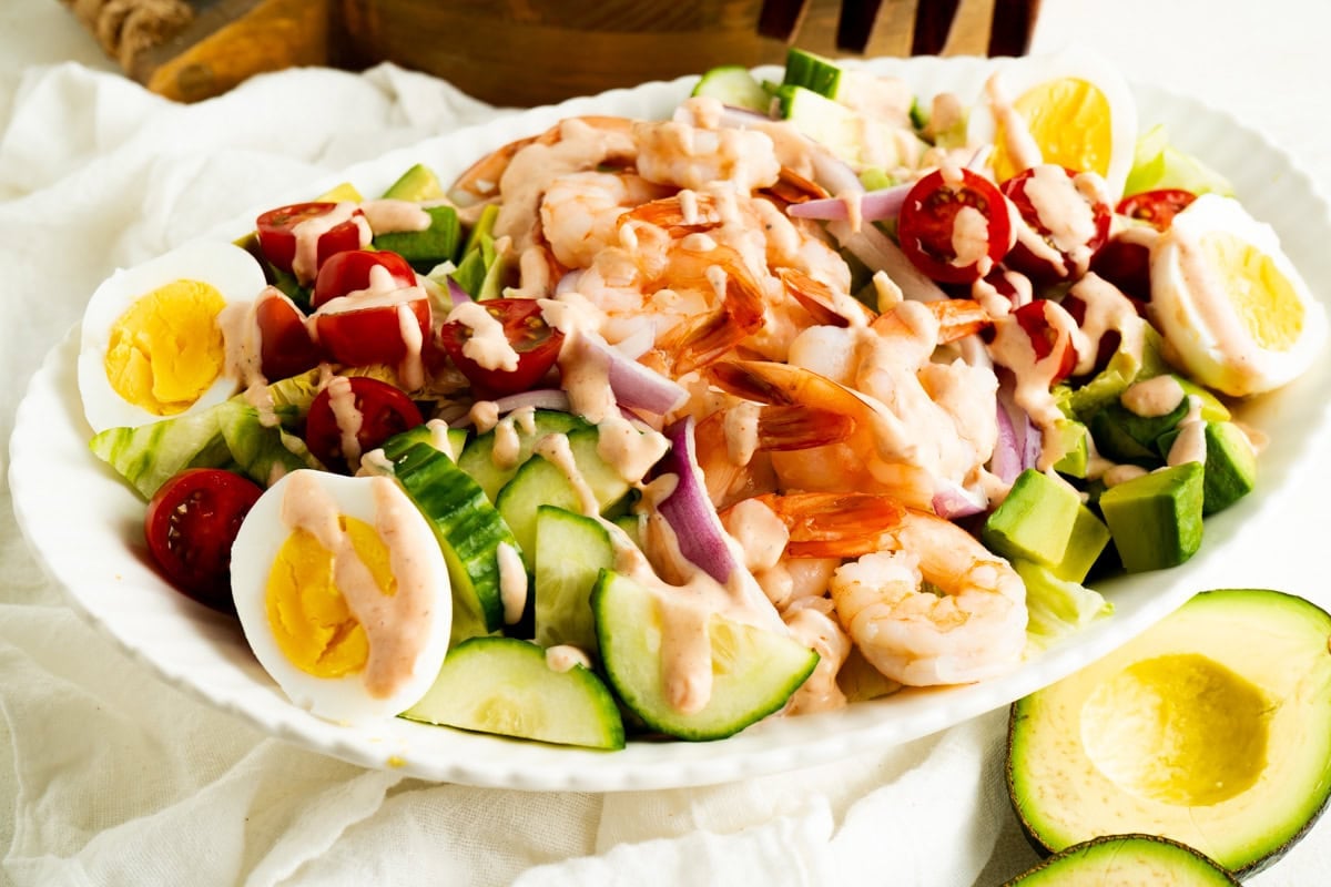 A platter of Shrimp Louie salad drizzled with dressing.