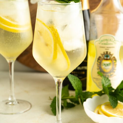Two glasses of limoncello spritz on a table.