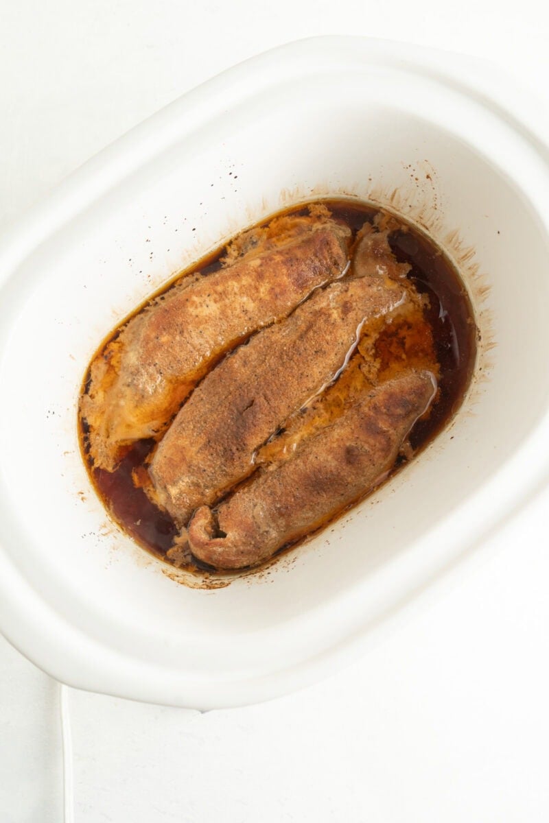 Pork tenderloin in crockpot with liquid.