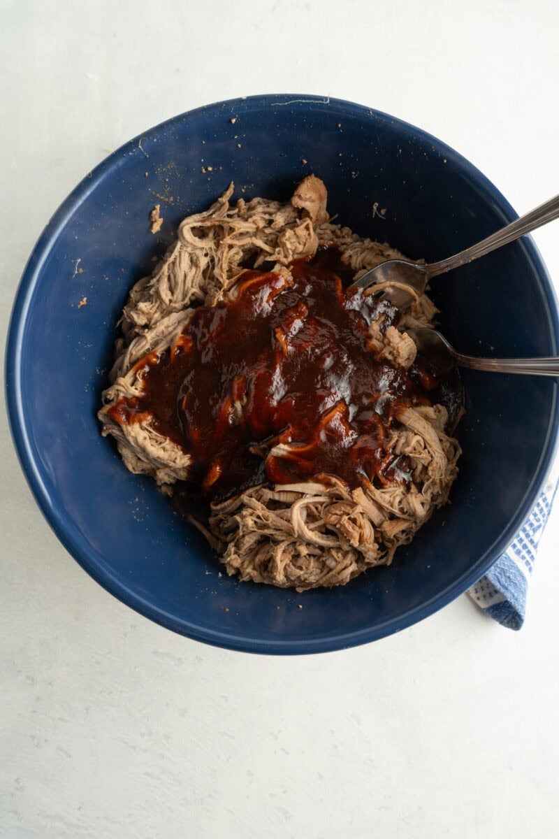 A bowl of shredded pulled pork with BBQ Sauce.