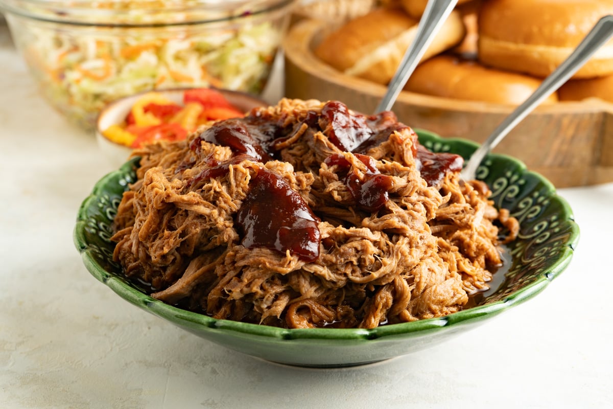 A bowl of pulled pork topped with BBQ sauce.