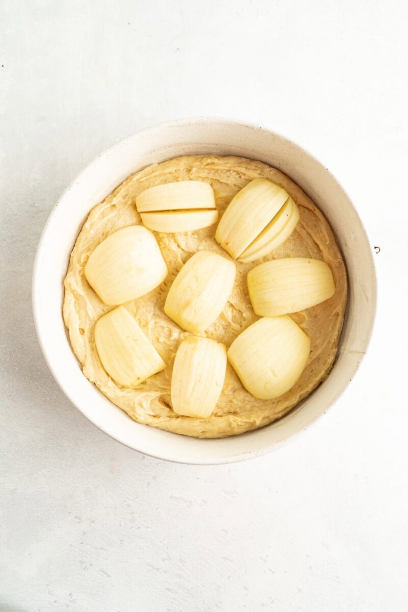 An uncooked apple cake inside a springfrom pan.