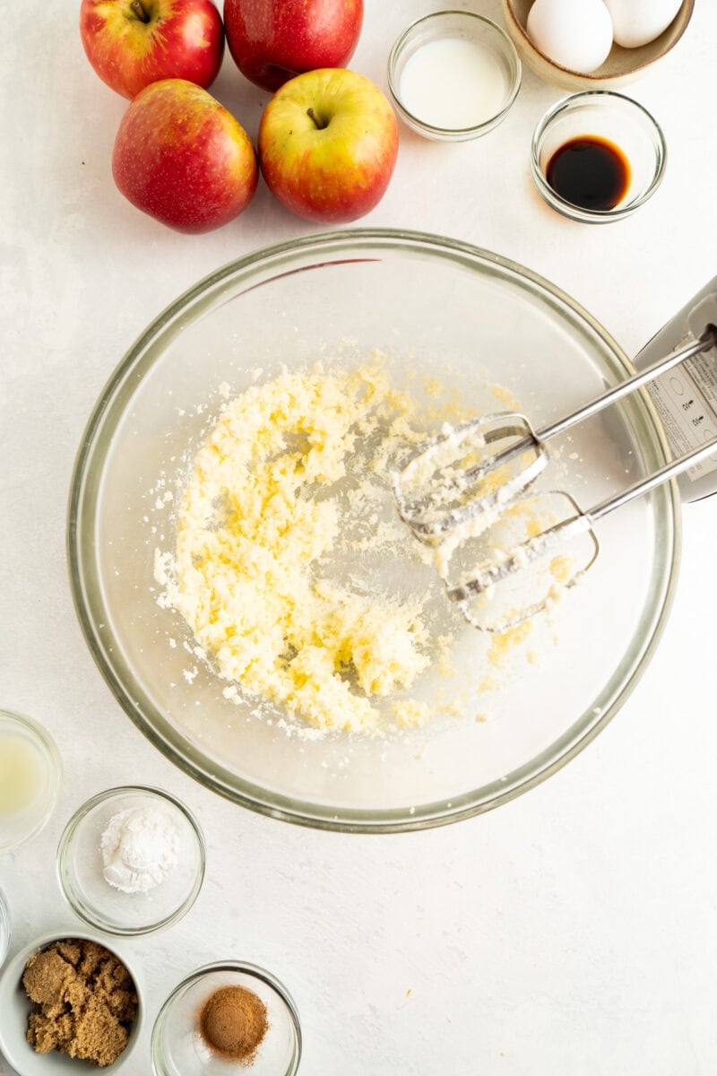 Sugar and butter being beaten in a bowl with a hand mixer.