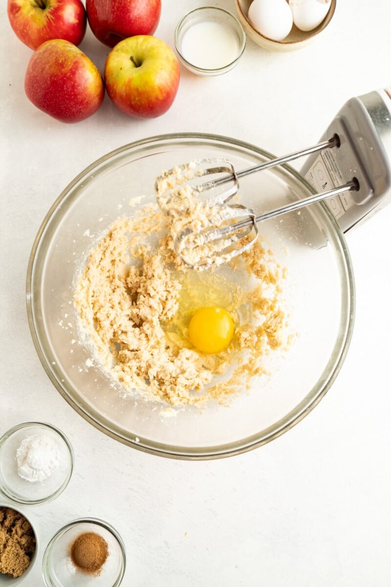 Eggs being added to a bowl of cake batter.