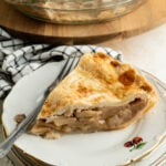 A single slice of apple pie on a plate.