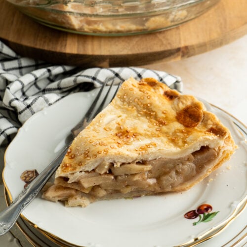 A single slice of apple pie on a plate.