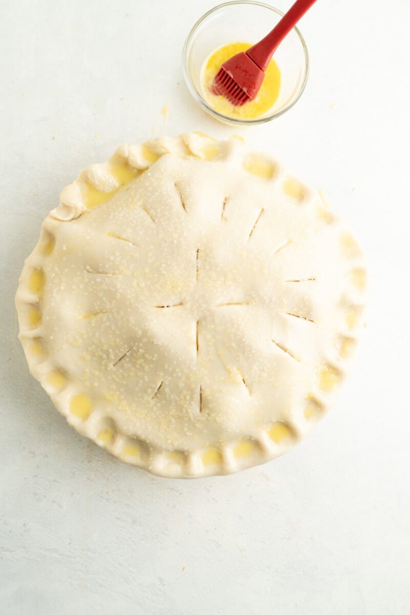 Uncooked pie being egg washed.