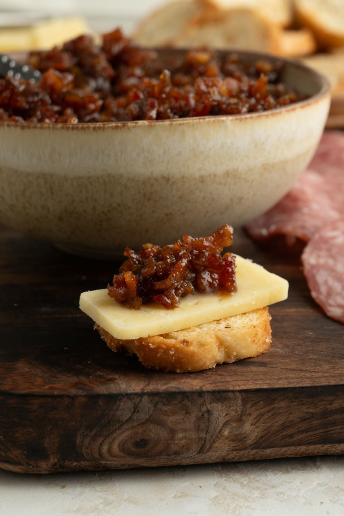 Close up of a crostini with bacon jam on it.