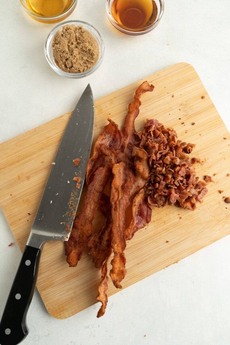 Bacon being chopped on a cutting board.
