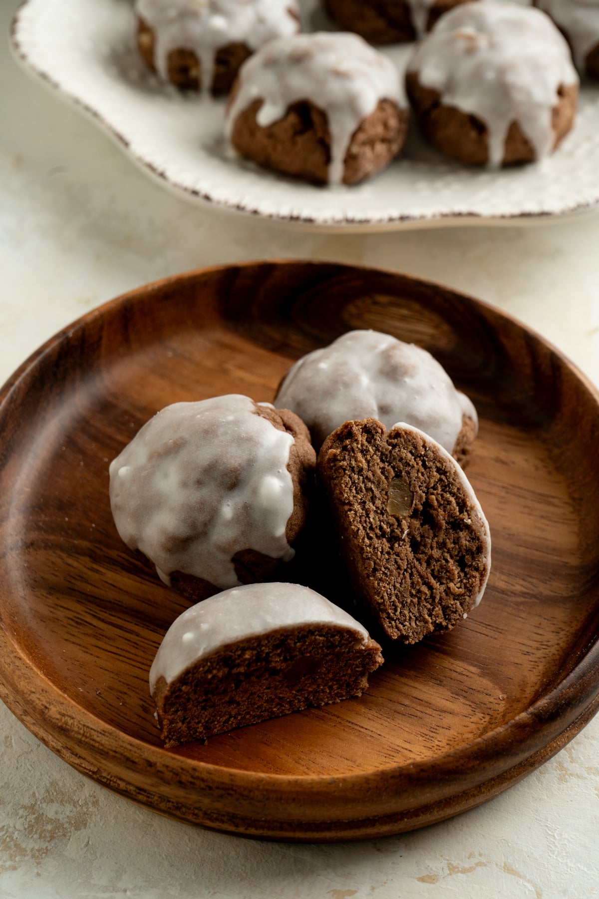 Chocolate spice cookies cut in half on a wooden plate.